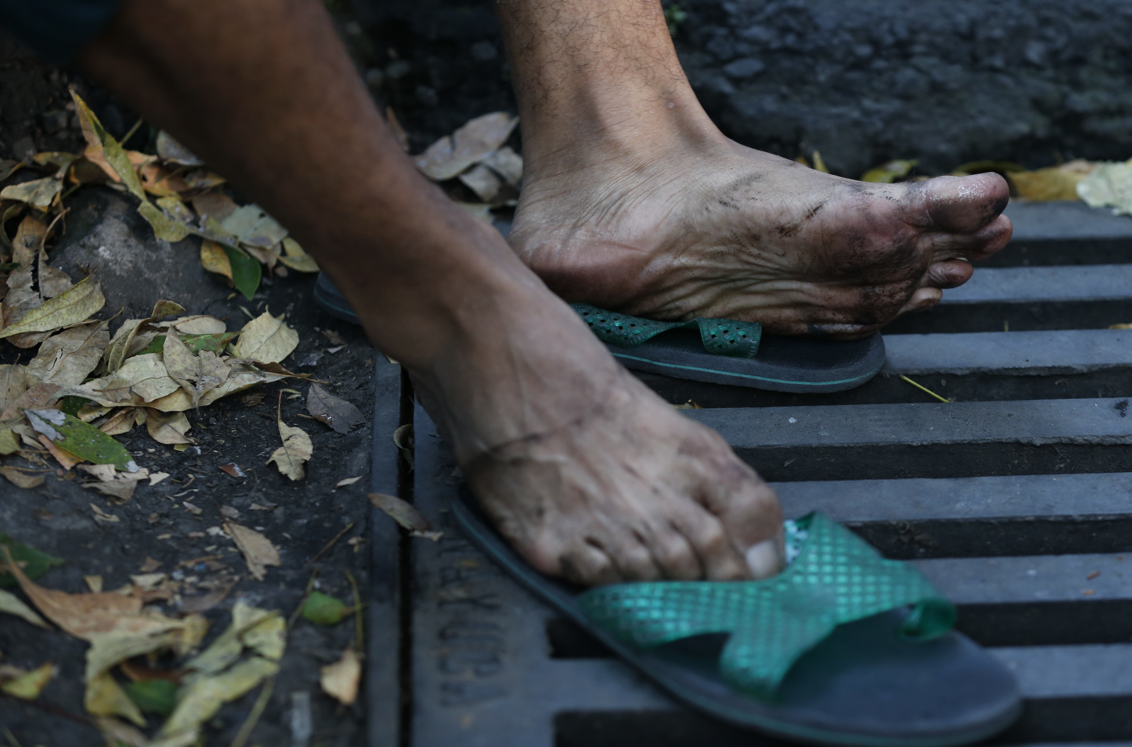 a man rests his feet after scores of central american migrants